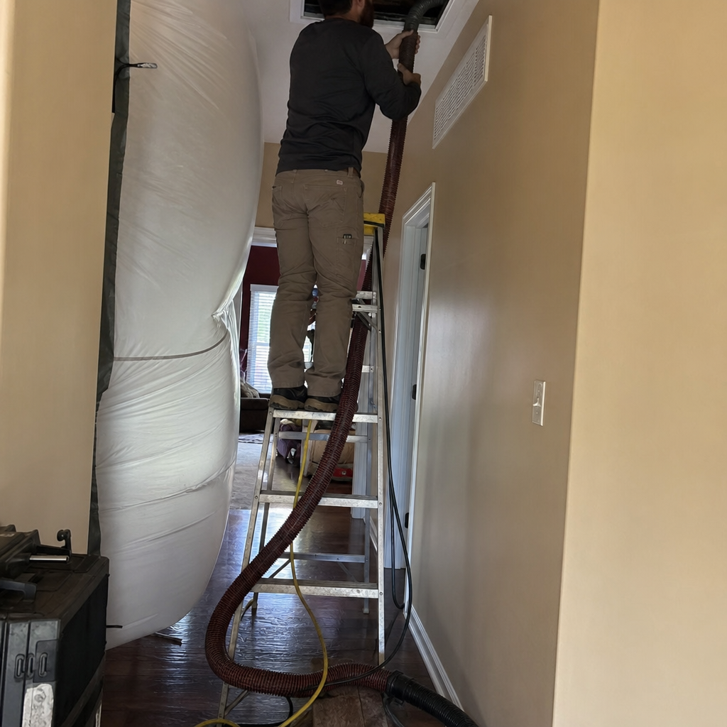 Technician performing professional residential air duct cleaning service using vacuum equipment